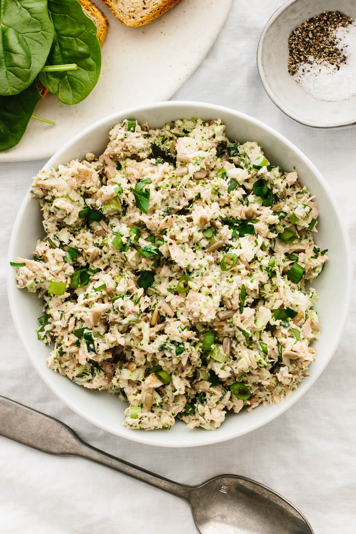 Broccoli tuna salad in a bowl next to a spoon.