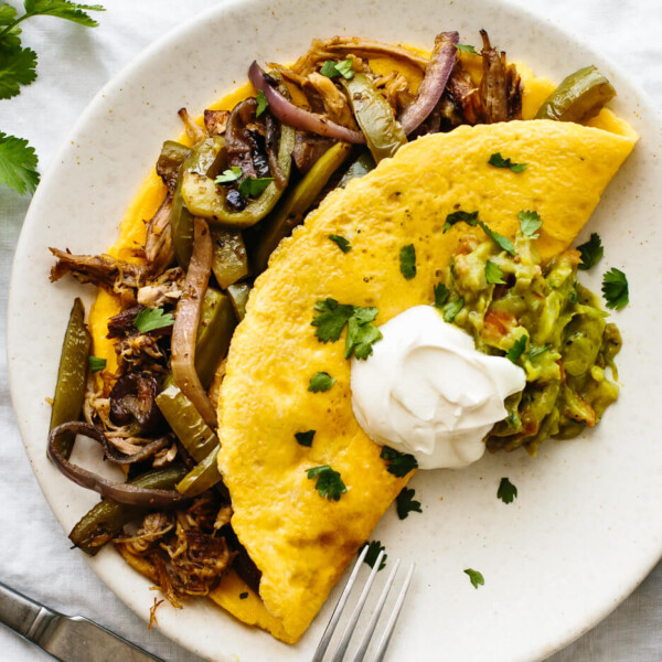 Omelette with carnitas and fajita veggies next to cilantro