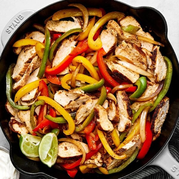 Chicken fajitas in a black skillet.