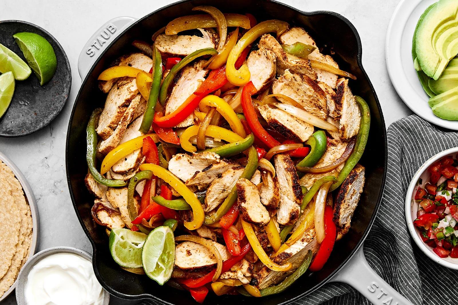 Chicken fajitas in a black skillet.