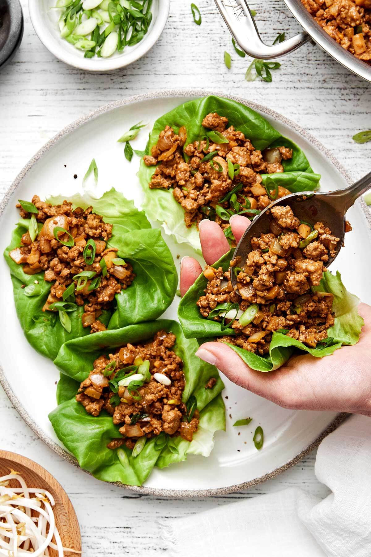 Assembling chicken lettuce wraps.