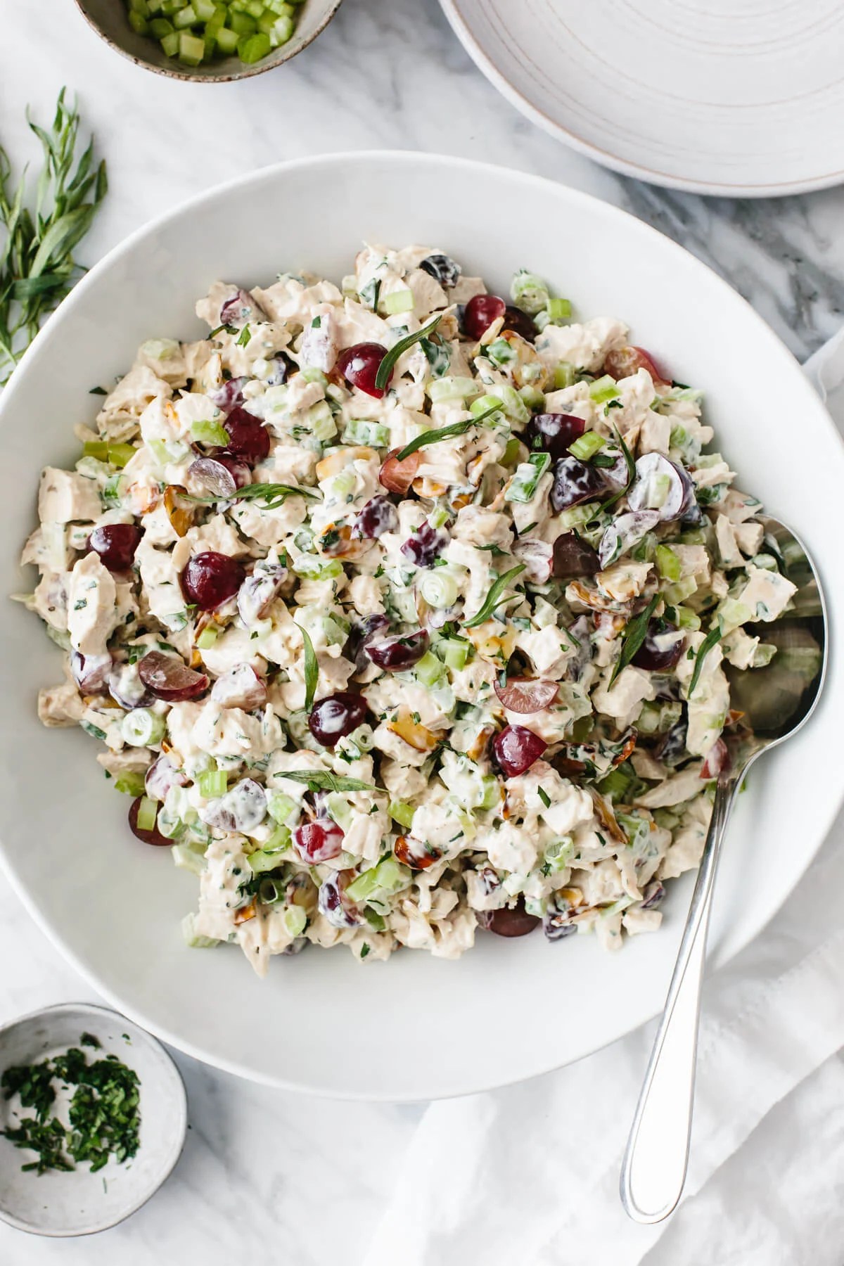 Chicken salad in a white bowl with spoon.