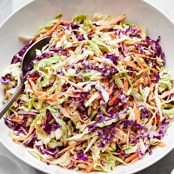 A white bowl of creamy coleslaw.