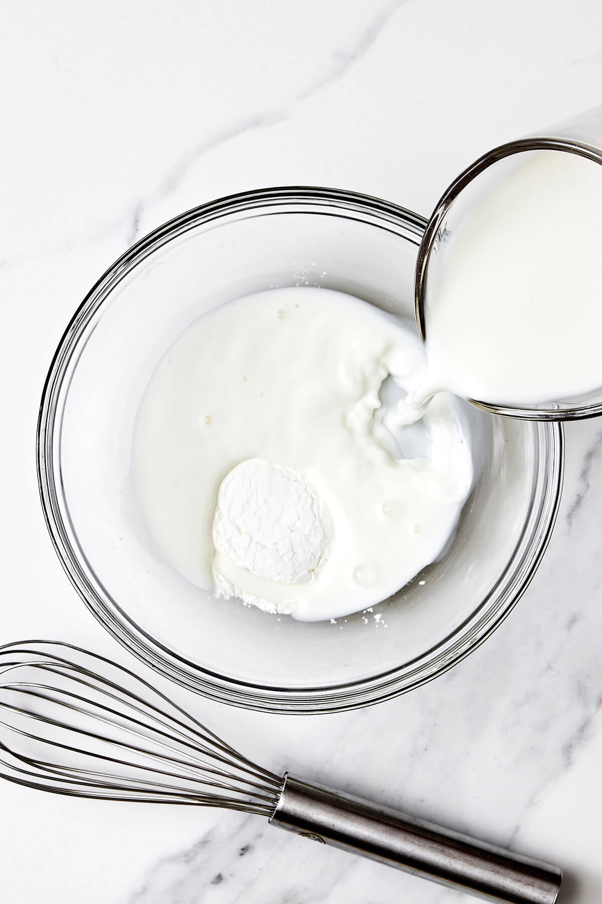 Whisking flour and milk in a bowl.