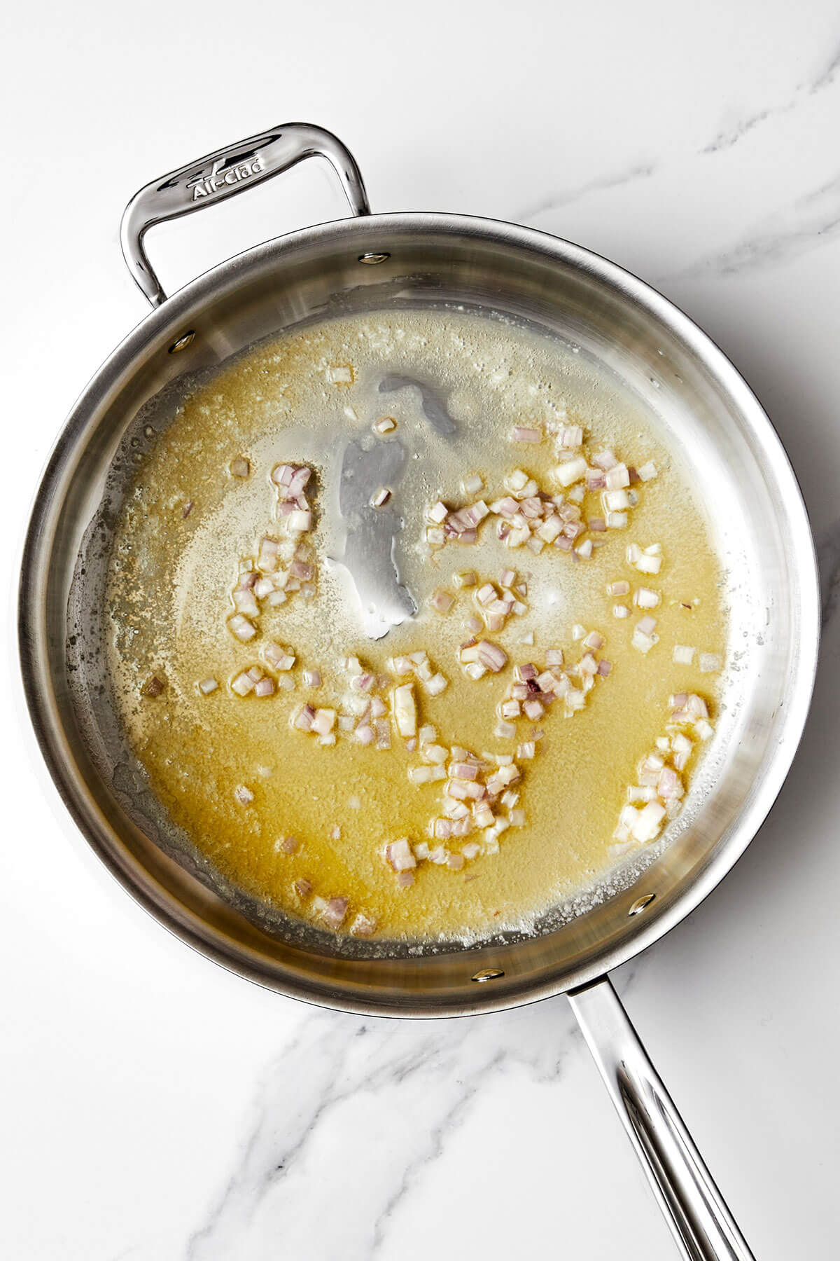 Cooking shallots in a pan.