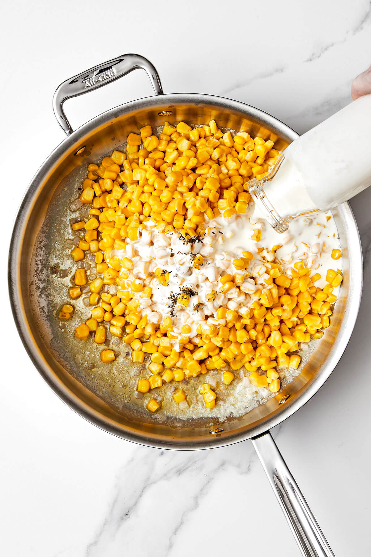 Cooking corn in a pan with cream.