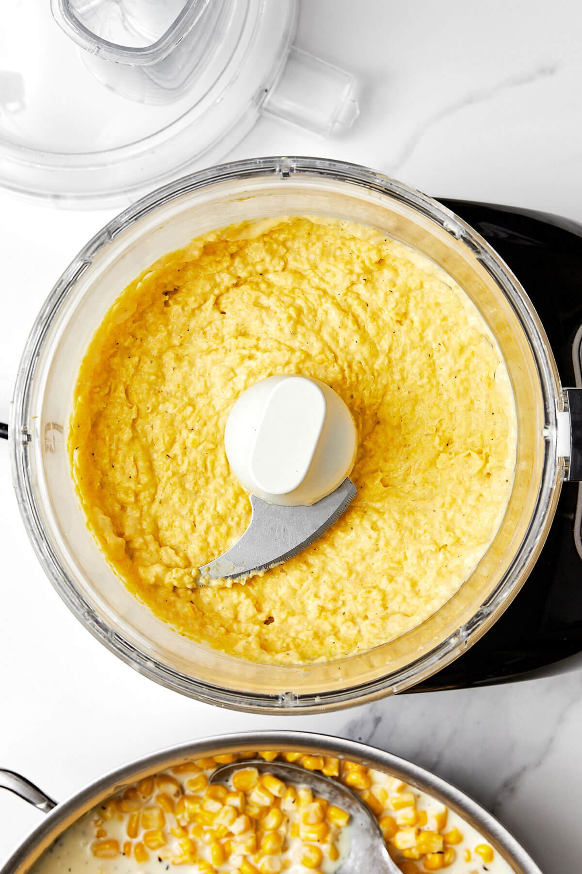 Blending creamy corn mixture in a food processor.