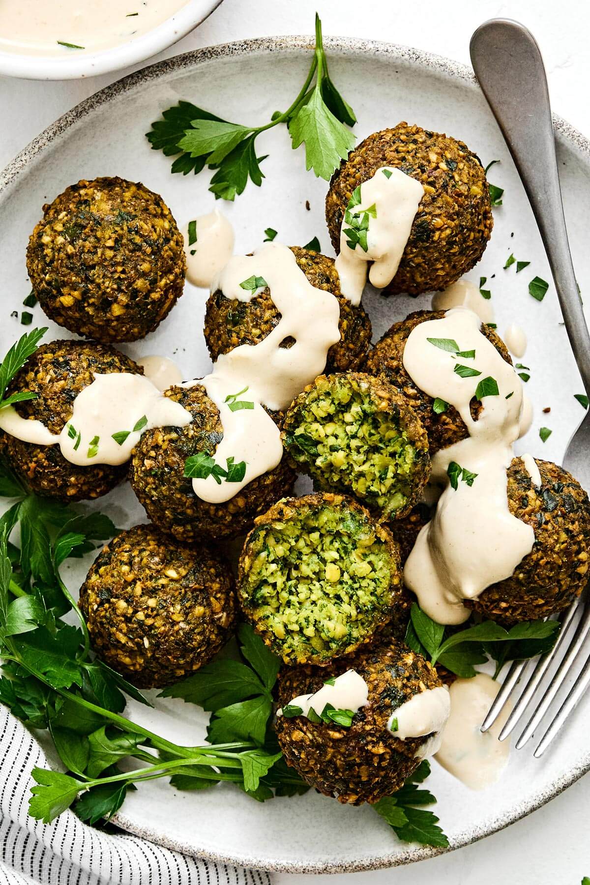 Falafels with tahini sauce and a fork.