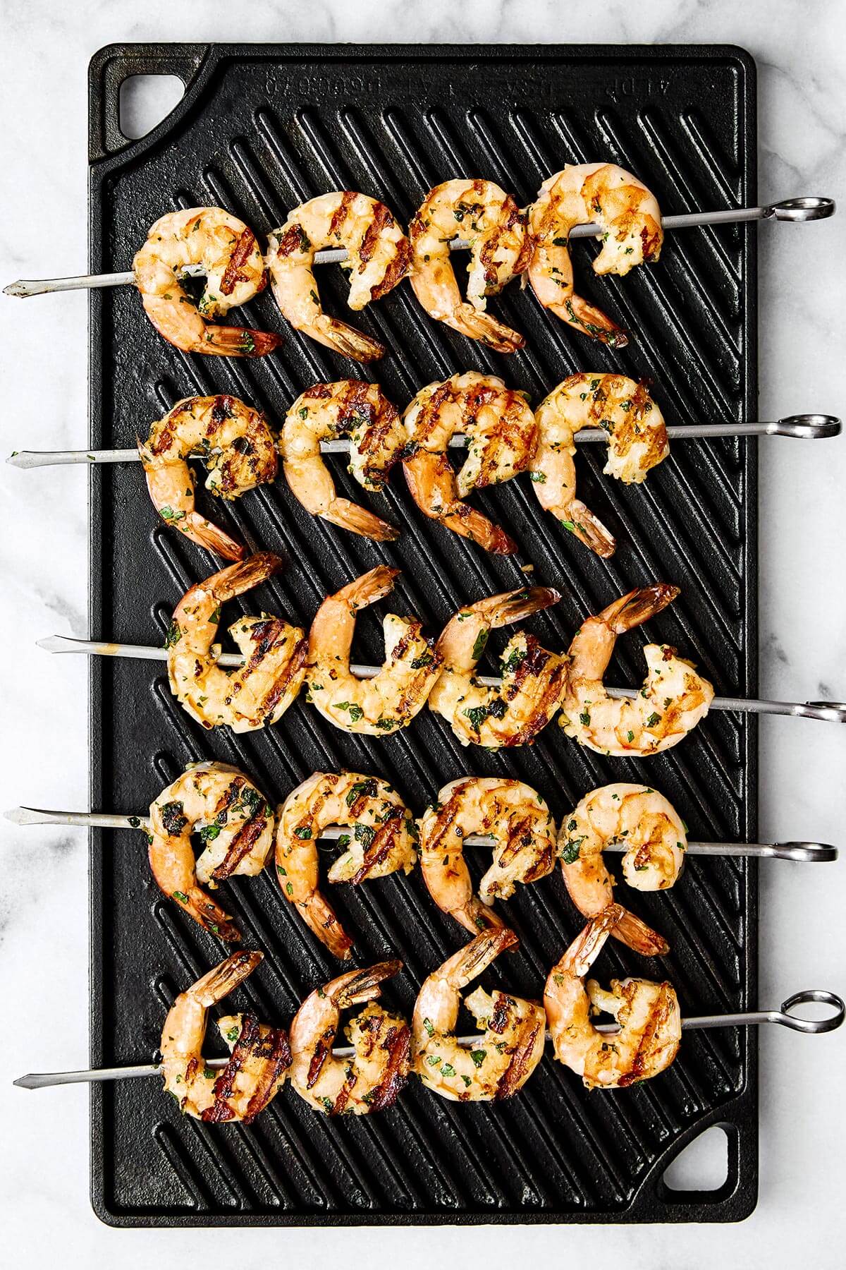 Grilling shrimp skewers on a grill pan.