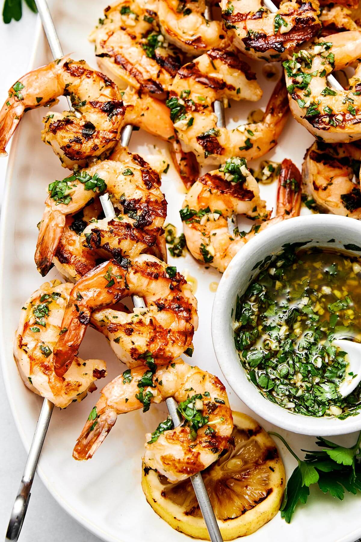 Grilled shrimp skewers with herb sauce.