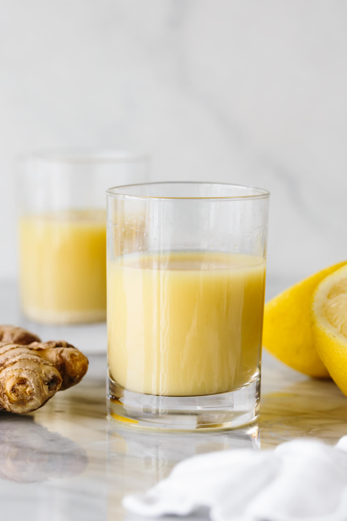 Two ginger shots in shot glasses.