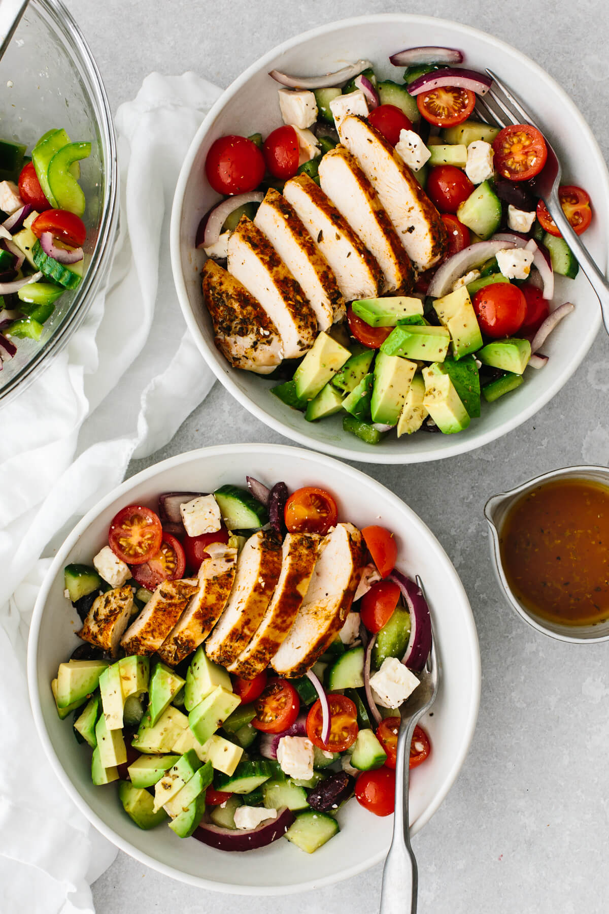 Two servings of Greek chicken salad in white bowls.