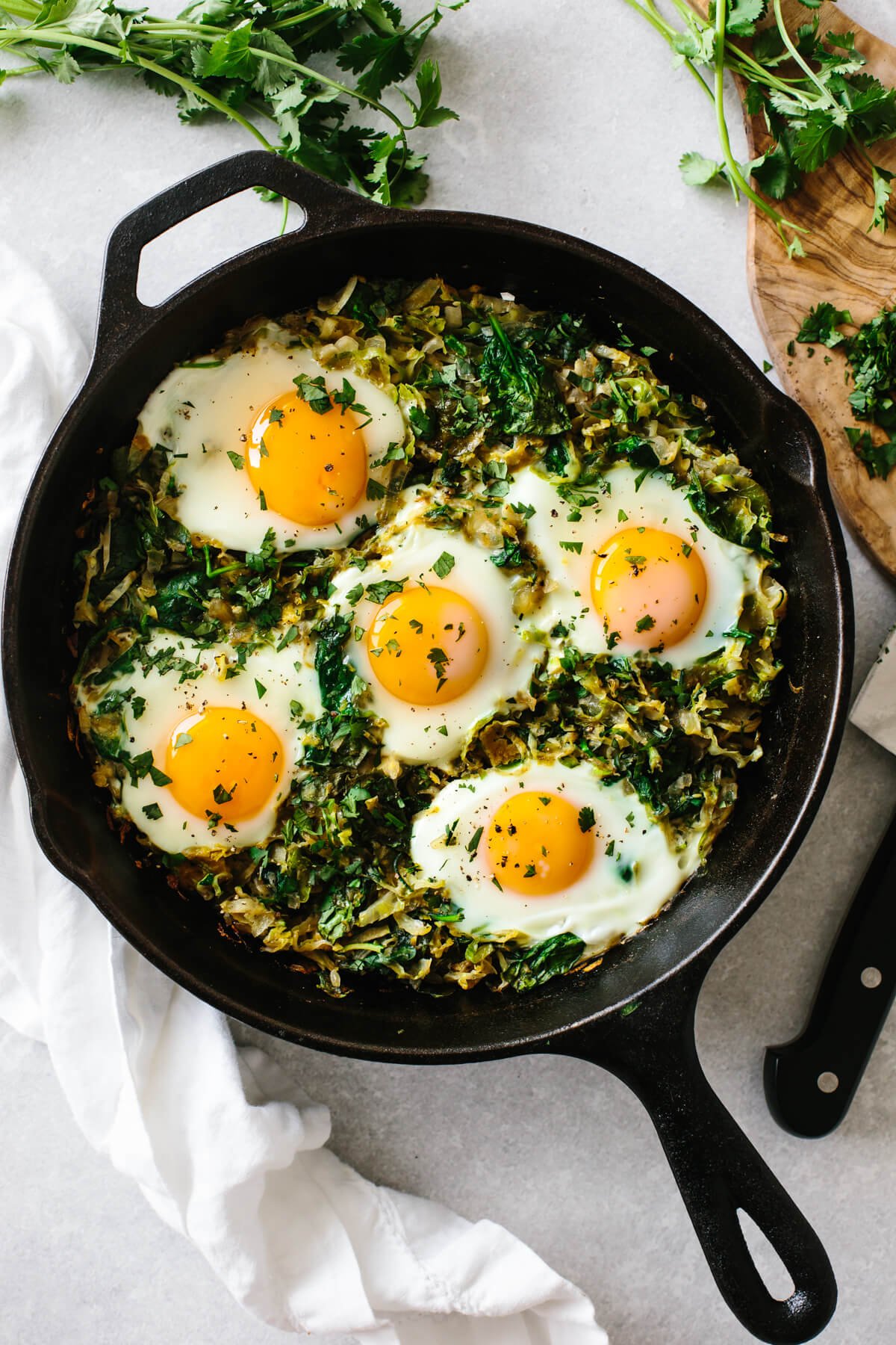 A cast iron pan filled with green shakshuka.