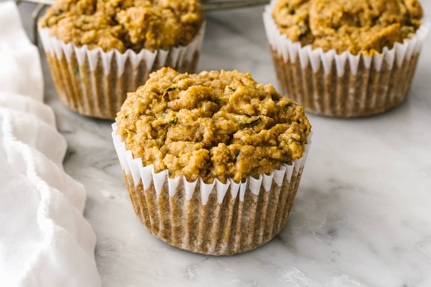 A few healthy zucchini muffins next to a napkin.