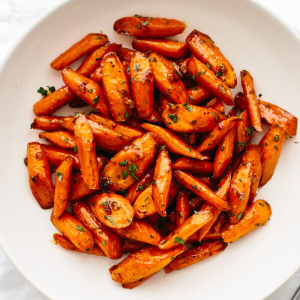 A large white bowl with honey glazed carrots.