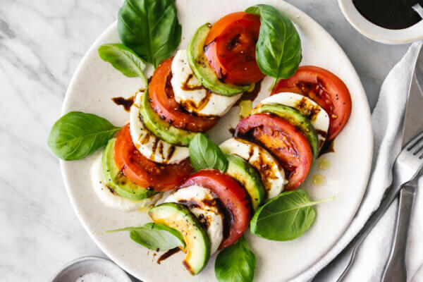 A white platter of avocado caprese salad