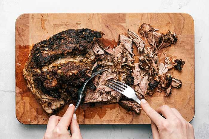 Shredding carnitas with forks.