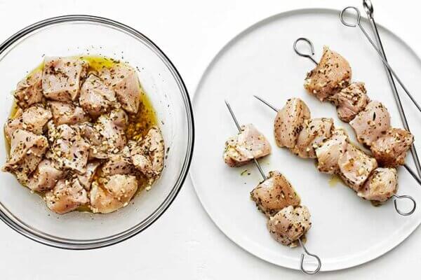 Adding chicken souvlaki on skewers