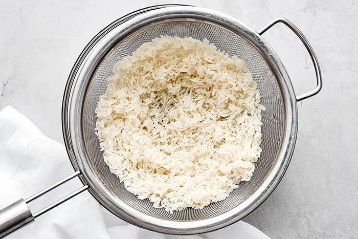 Washing rice in a sieve.