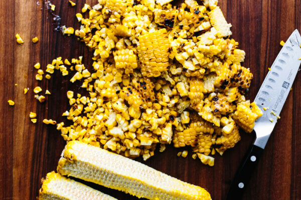 Shaving kernels off a corn on the cob for corn salad