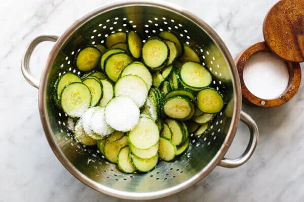 Adding salt on cucumbers for cucumber salad