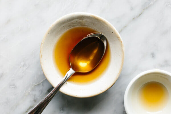 Cucumber salad dressing in a small bowl with a spoon