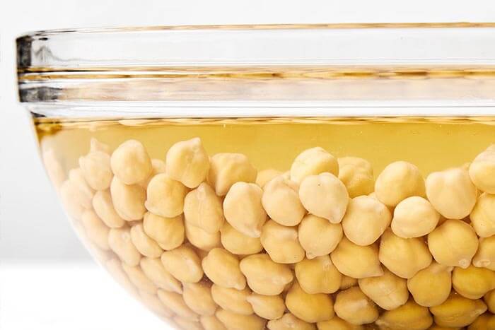 Soaked chickpeas in a glass bowl.