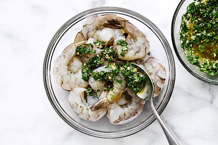 A bowl of raw shrimp and marinade.