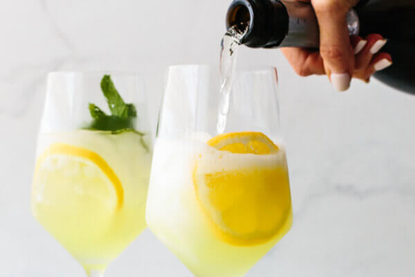 Pouring prosecco to make limoncello spritz