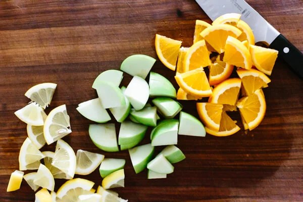 Chopping fruit for sangria on a cutting board.