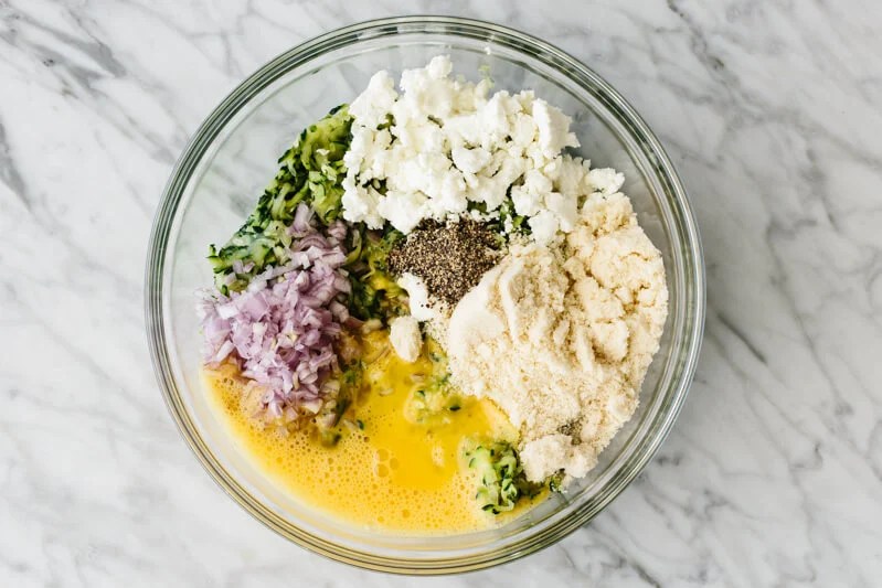 Zucchini fritter ingredients in a mixing bowl.