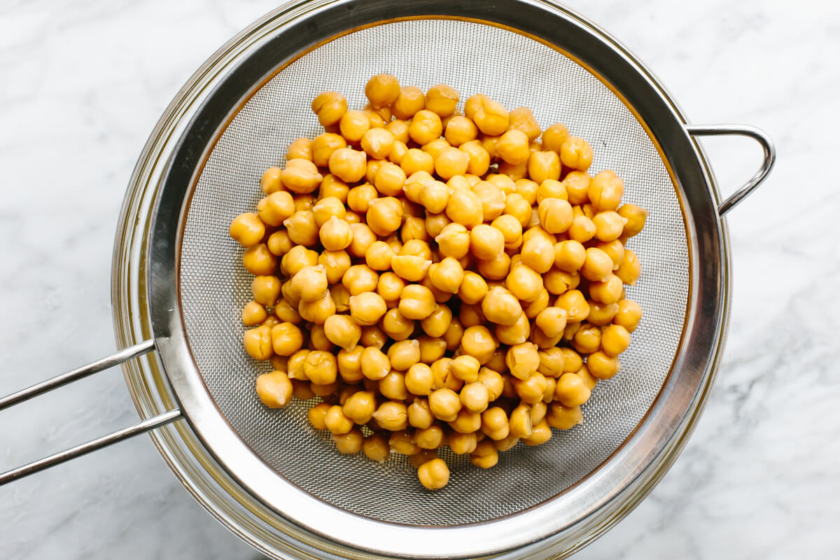 Washing chickpeas in a sieve for hummus