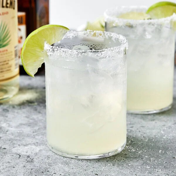 Two glasses of margarita with limes.