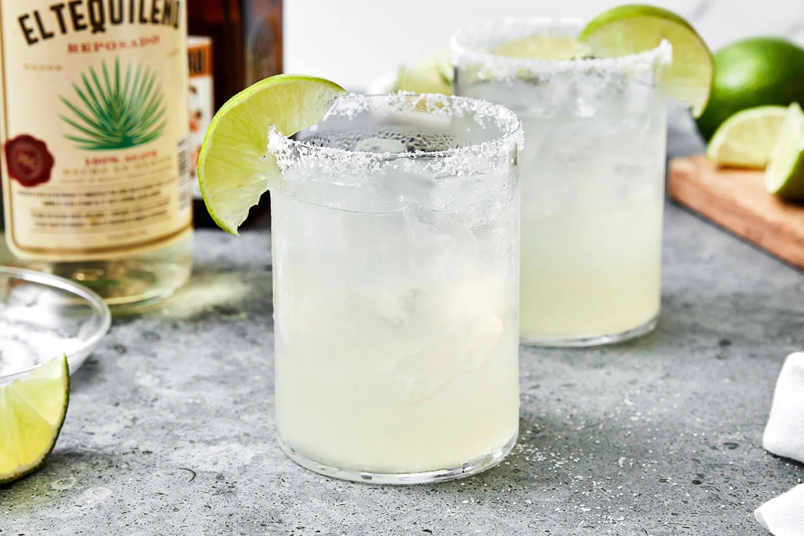 Two glasses of margarita with limes.