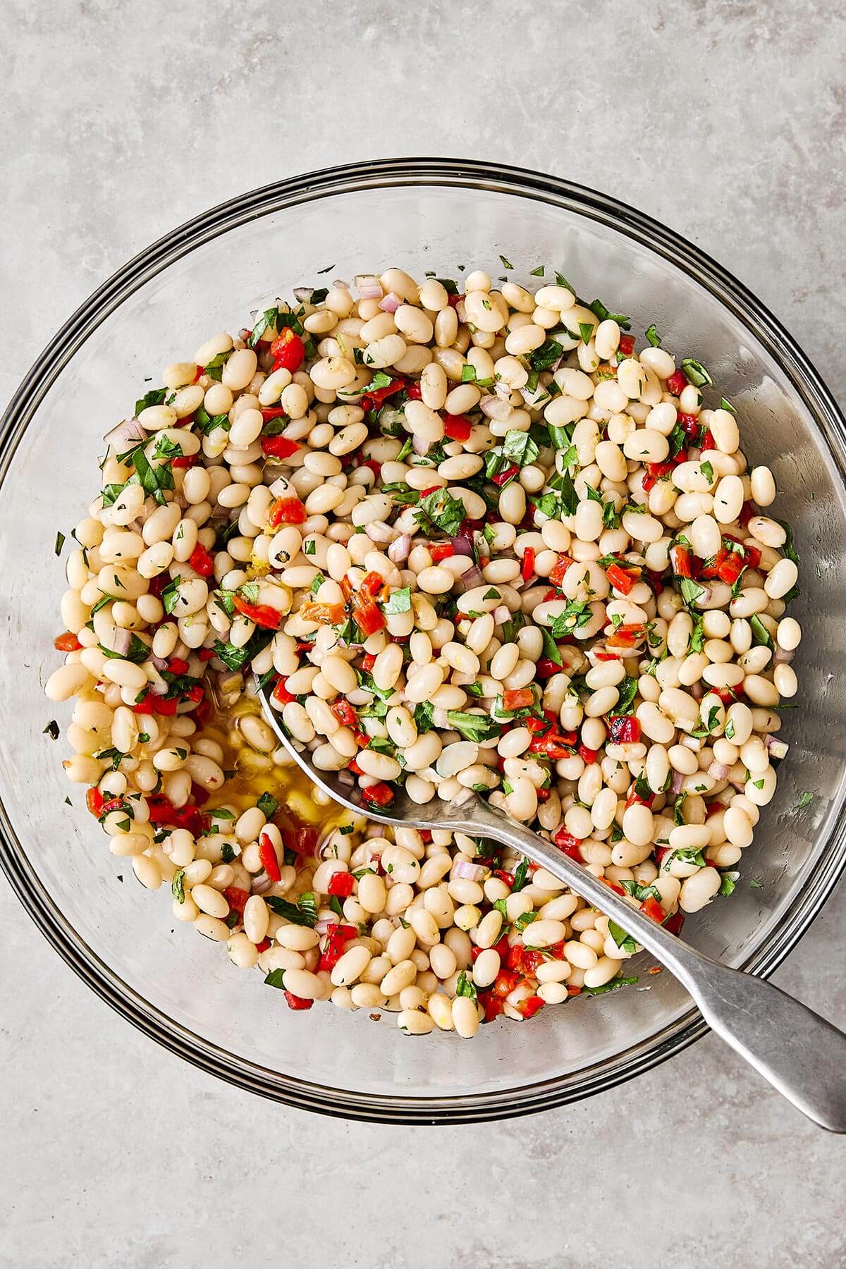 Marinated white beans with a spoon.