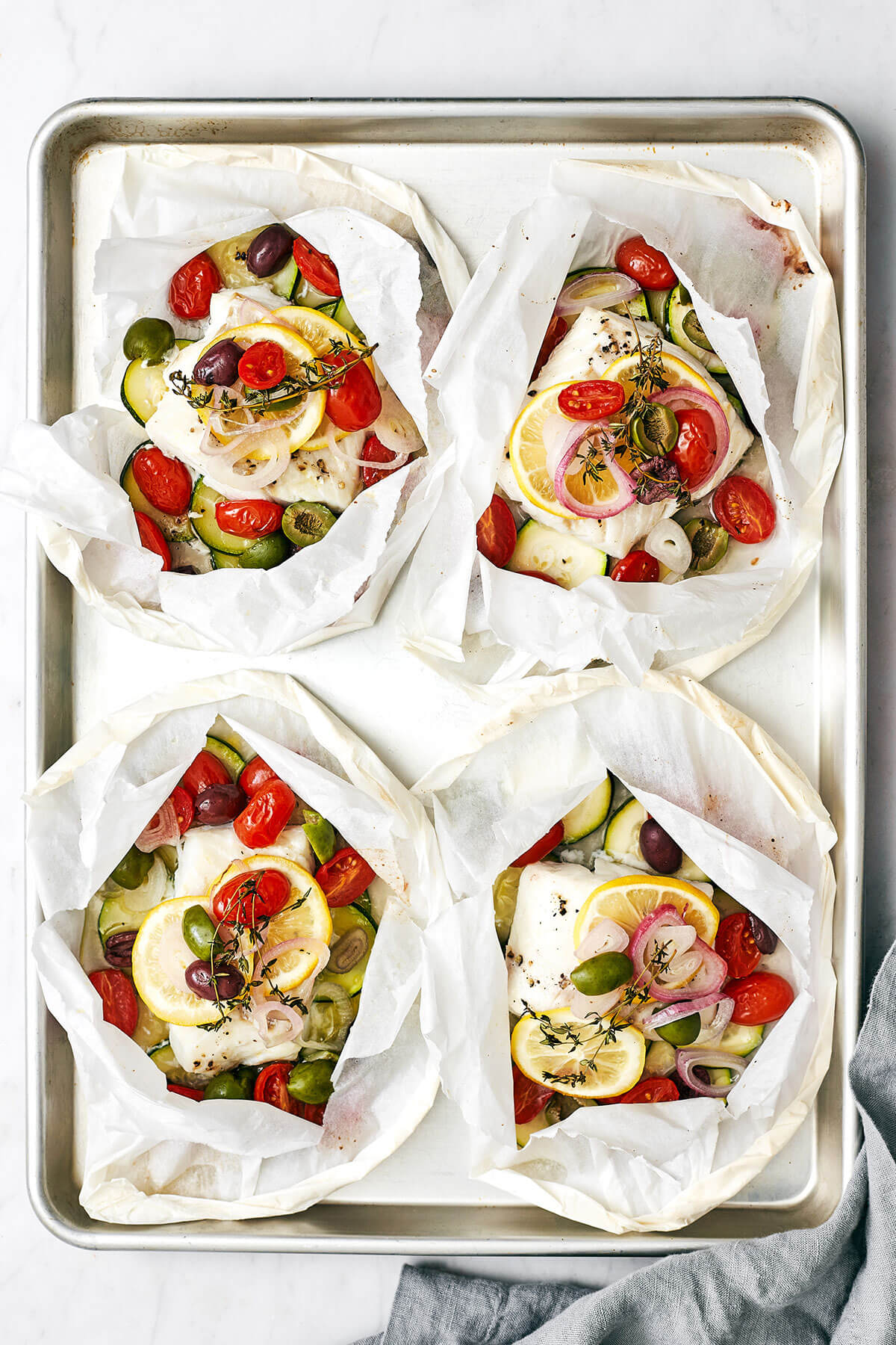 Cods en papillote on a baking sheet