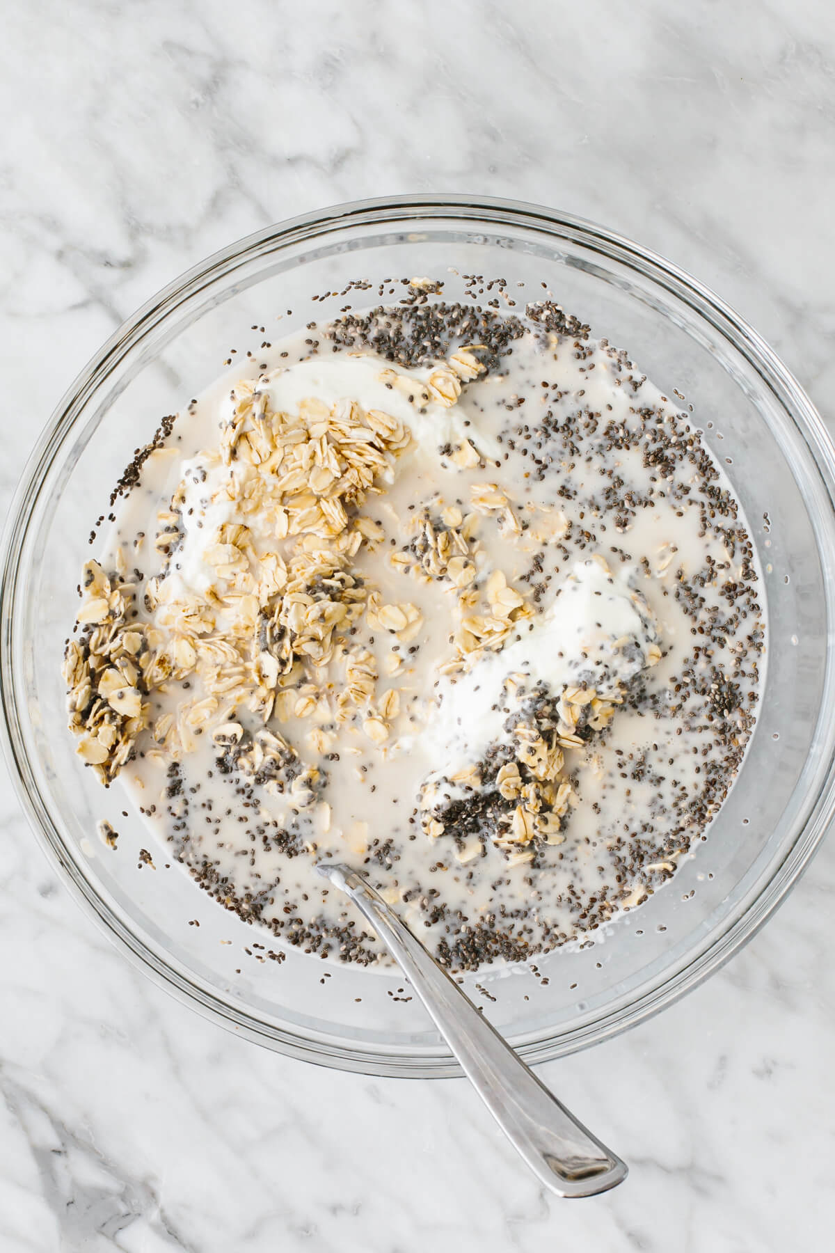 Stirring ingredients for overnight oats in a bowl. 