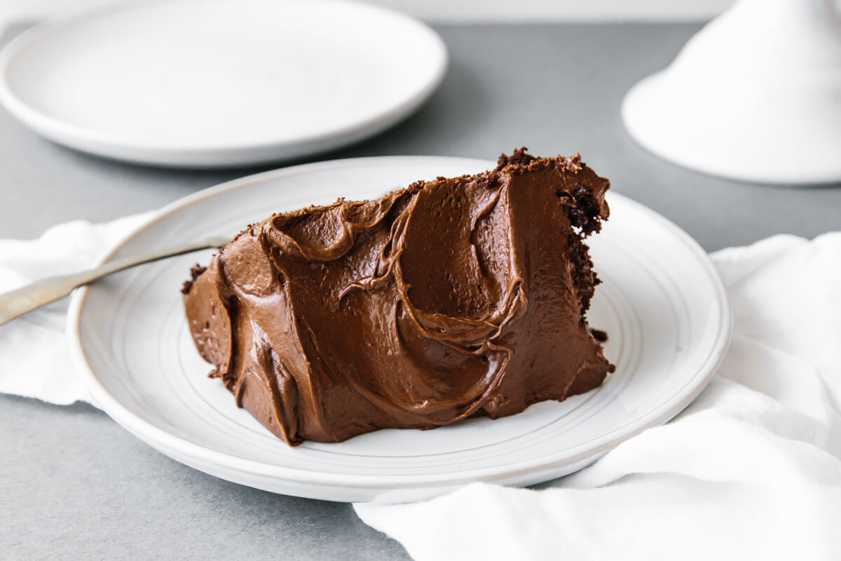 A single slice of paleo chocolate cake on a white plate.