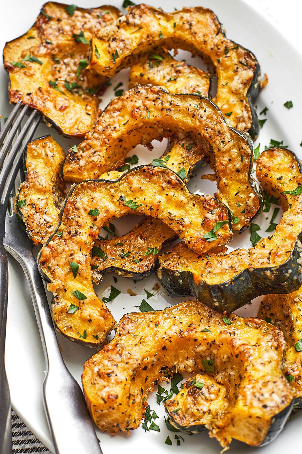 Parmesan herb roasted acorn squash on a platter with a fork