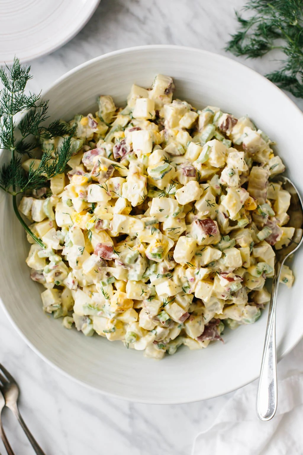 Potato salad in a white bowl.