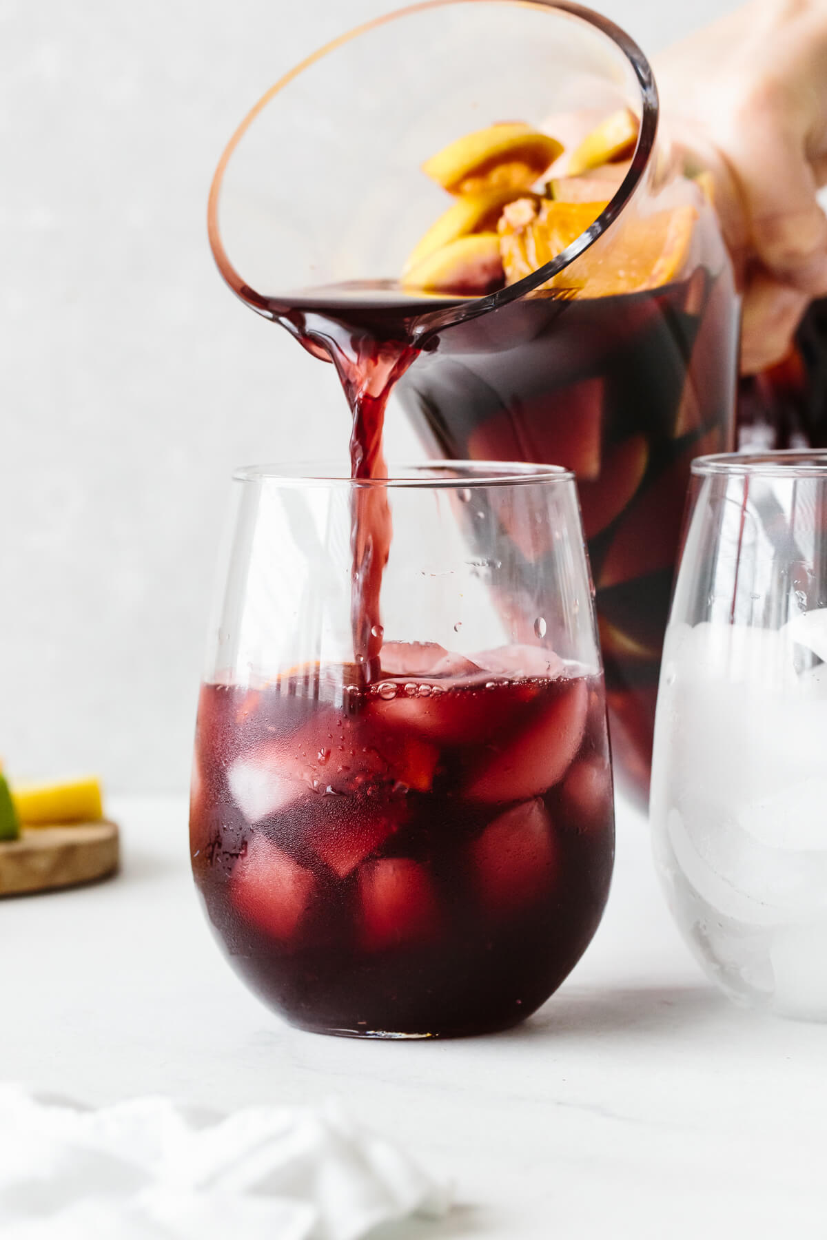 Pouring sangria into a glass with ice.