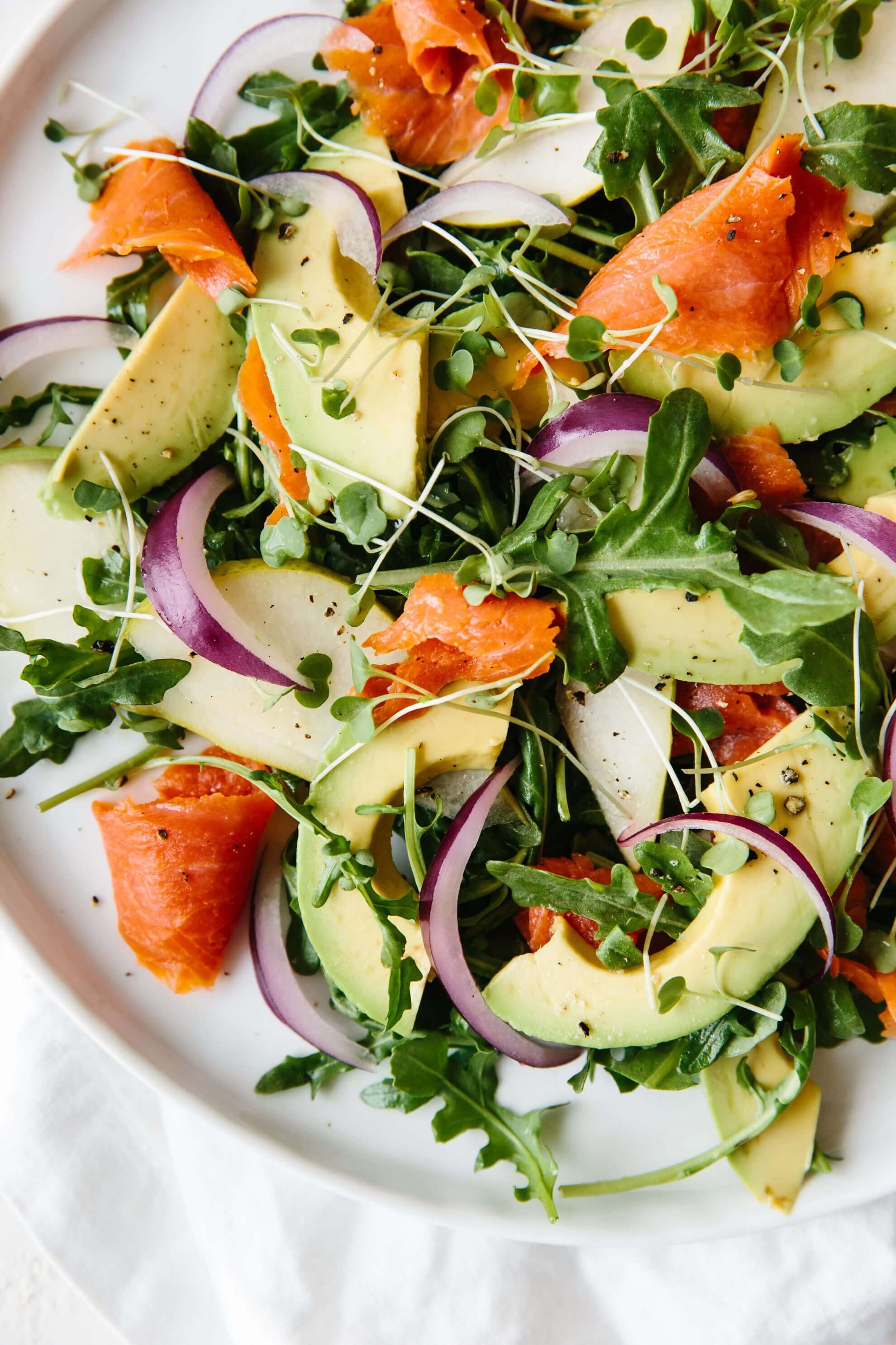 An easy and delicious arugula salad recipe made with baby arugula, smoked salmon, avocado, pear and red onion.