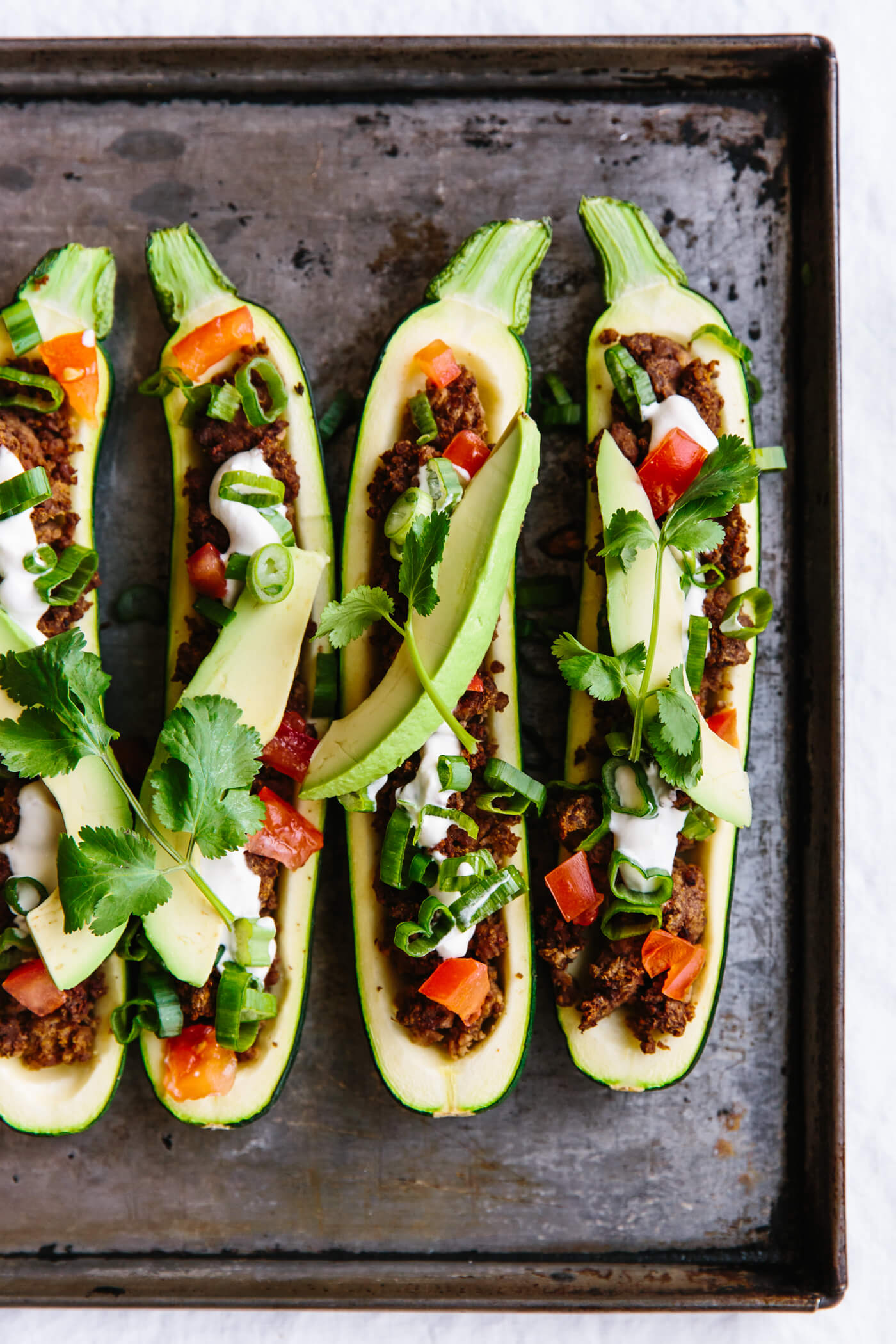 Taco stuffed zucchini boats on a sheet pan.