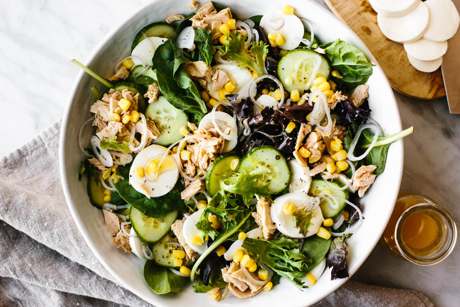 A large white bowl of tuna, cucumber, and mozzarella salad