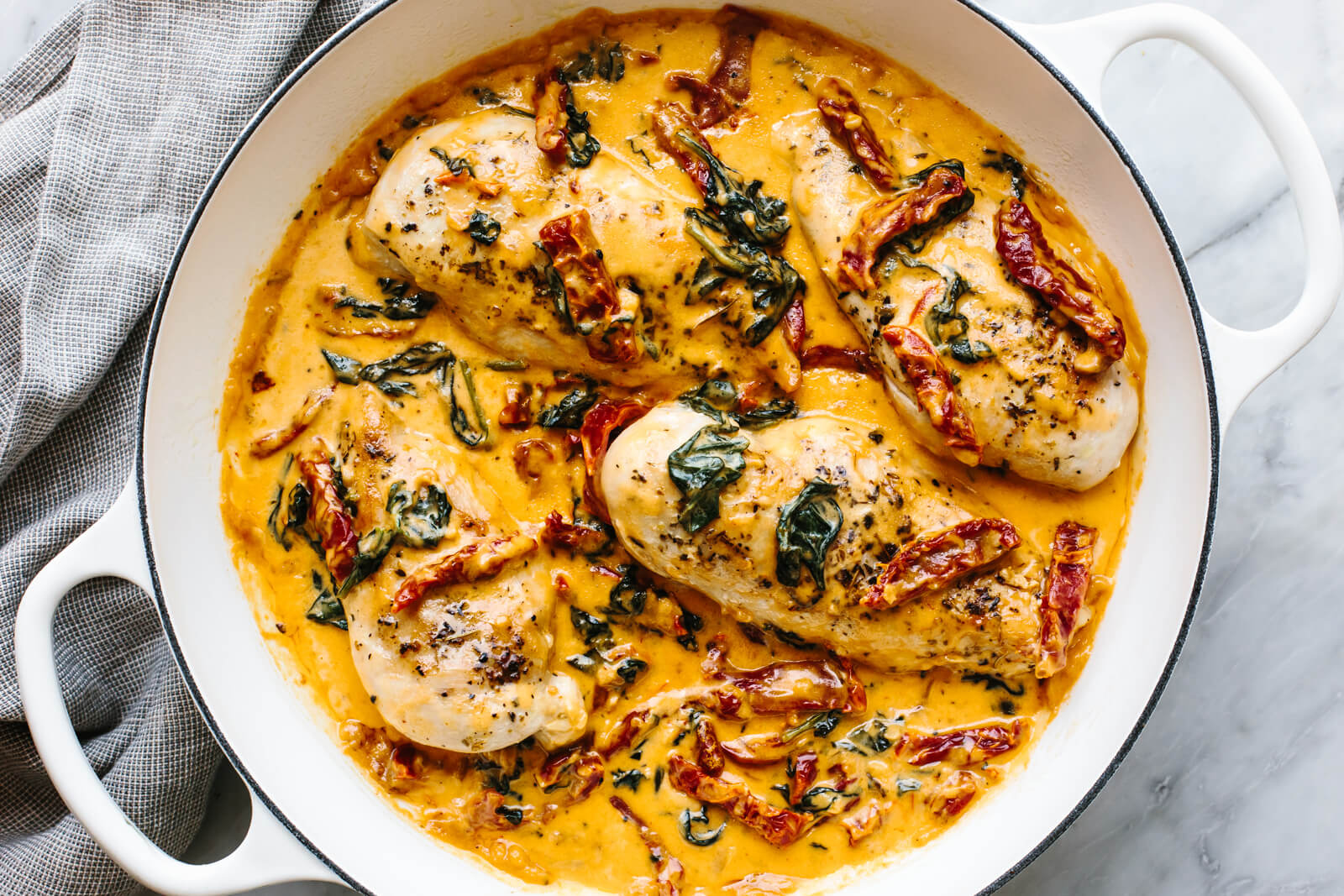 A white skillet of tuscan chicken