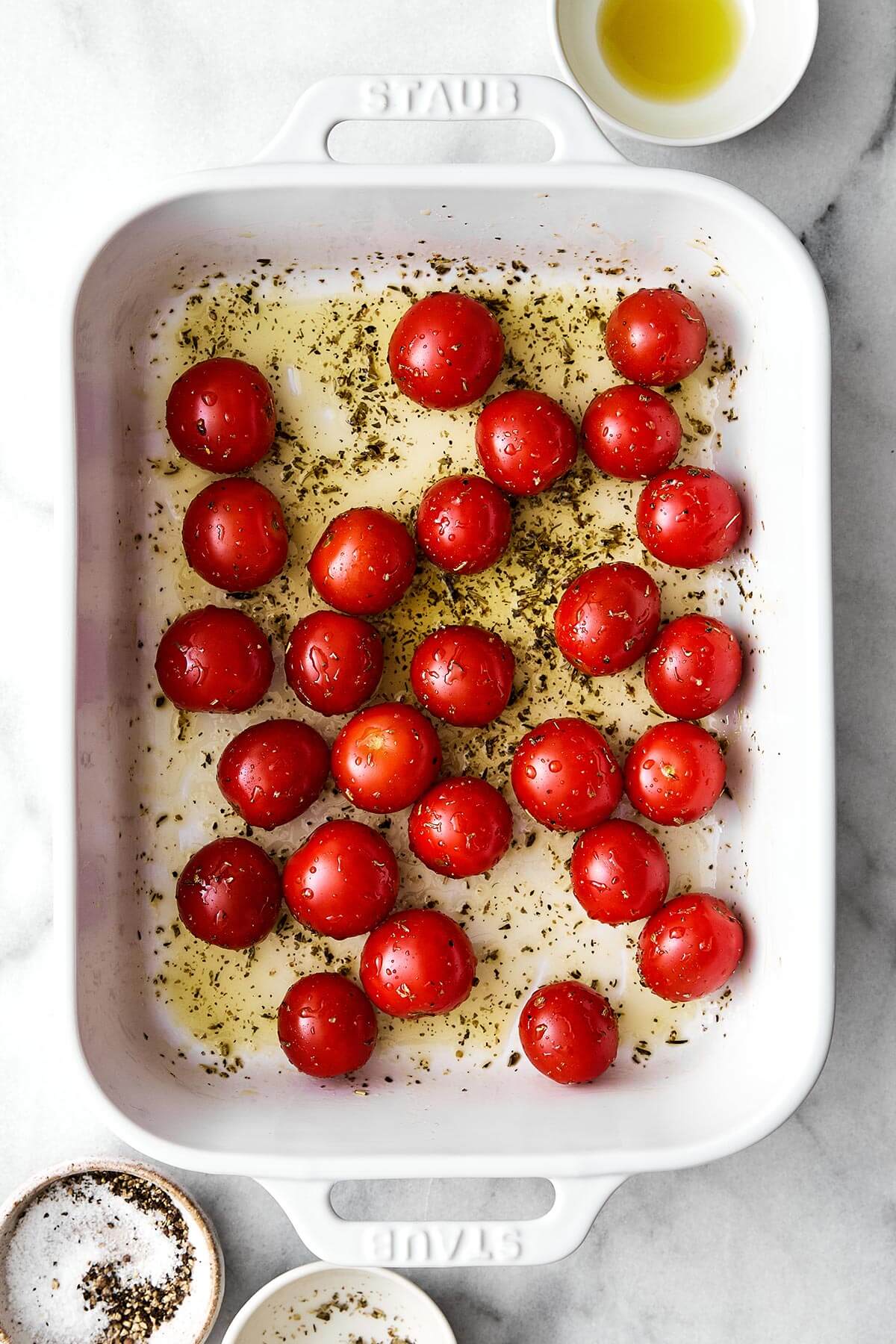 Roasting cherry tomatoes in a baking dish.