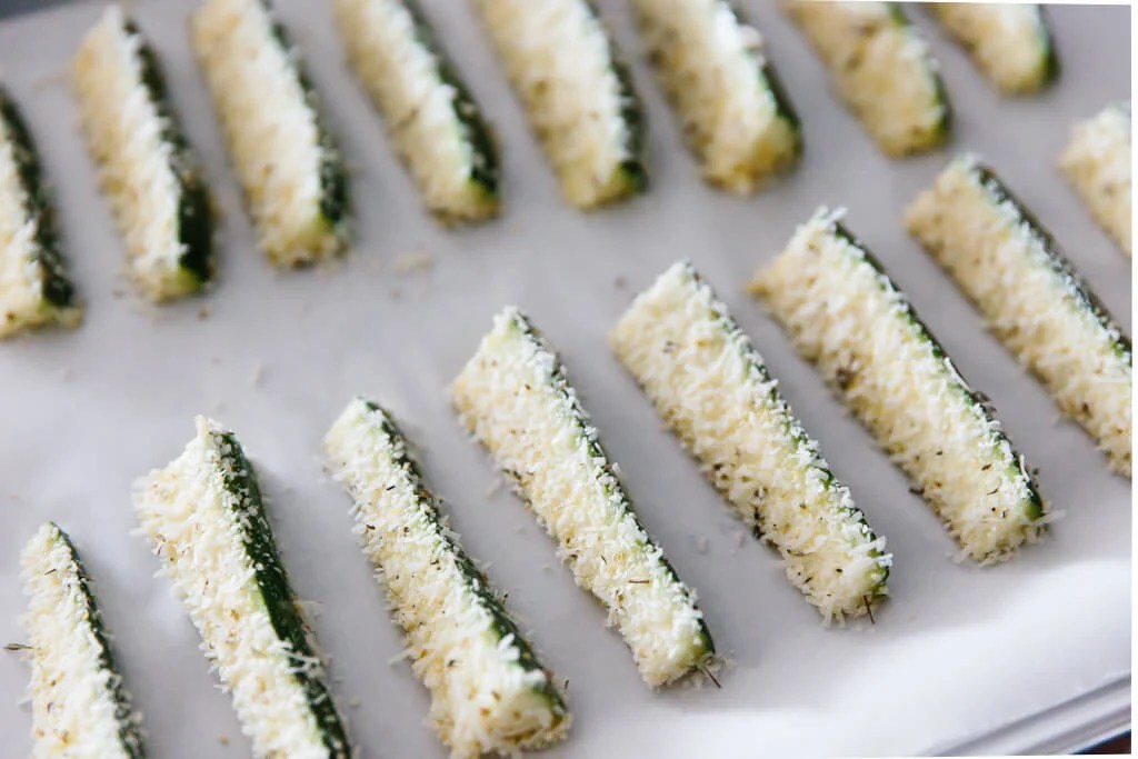 Zucchini fries coated in parmesan and ready to be baked. 