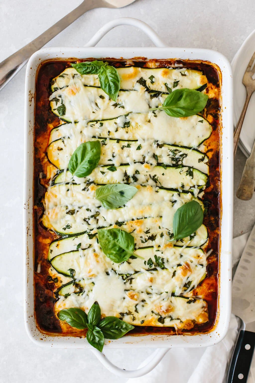 Zucchini lasagna in a white casserole dish.