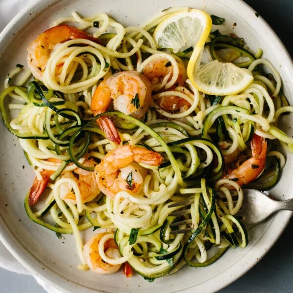 Zucchini noodles on a plate with lemon garlic shrimp.